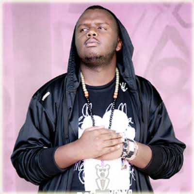 Mejja in black hoodie, promo shot on pink backdrop